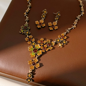 Gros plan sur une parure de bijoux fleurs vintage avec strass colorés sur cuir brun