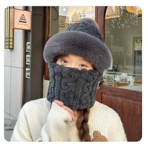 Close-up of thick knitted winter hat and scarf set with dark grey faux rabbit fur lining