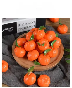 Realistic PVC mini mandarin oranges with green leaves on a wooden tray for dollhouse decor