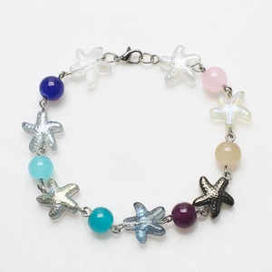 Detail of DIY bracelet featuring colorful glass beads and metallic starfish pendants