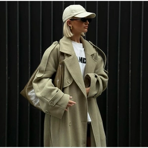 Detail of olive green wool coat featuring wide lapels, epaulettes and buckled sleeve cuffs
