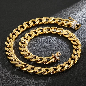 Iced out gold Cuban link chain necklace with crystal encrusted box clasp on black background