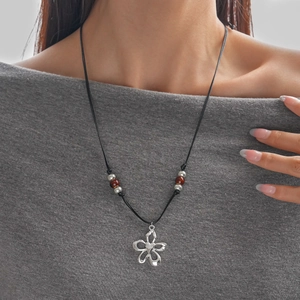 Détail du collier pendentif fleur avec perles en céramique sur cordon ciré noir