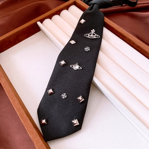 Detail of black canvas tie with silver Saturn ring and cross metal charms
