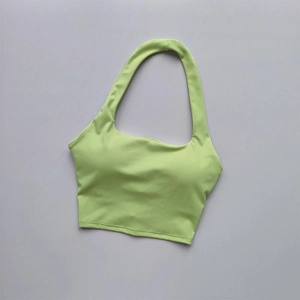 Detail of avocado green halter sports bra with ruched fabric and built-in chest pads