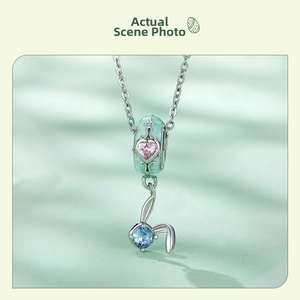 Detail of S925 silver Easter egg charm with heart gemstone and rabbit pendant on green silk