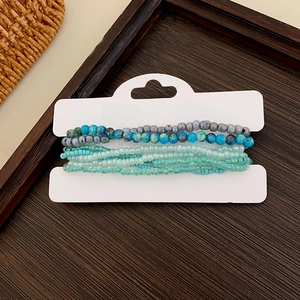 Detail of multi-layer beaded star bracelets in blue and turquoise on display card