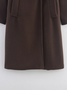 Vue détaillée du manteau en laine marron foncé montrant la poche, la patte et l'ourlet