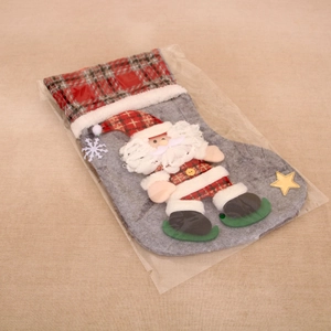 Detail of grey felt Christmas stocking with 3D Santa Claus and red plaid fabric trim