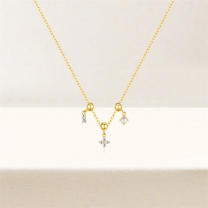 Close-up of gold pendant necklace featuring cubic zirconia and white pearl accents