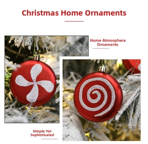 Close-up of red Christmas baubles with white glitter spiral patterns and gold hanging strings