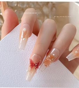 Detailed view of 3D Maillard brown resin butterfly and camellia nail charms on nails