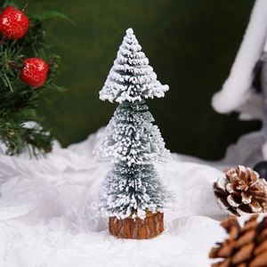 Close-up of mini snow-flocked Christmas tree with a natural solid wood base