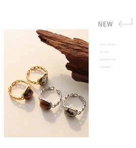 Detail of vintage tiger eye and marble stone inlay on gold and silver chain rings