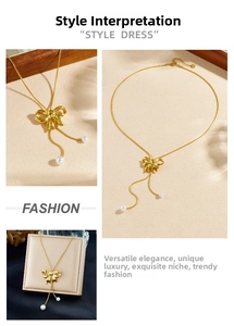Detail view of a gold bow pearl pendant necklace with a long tassel snake chain