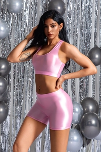 Dettaglio del set yoga rosa lucido che mostra il tessuto metallico su gilet e shorts