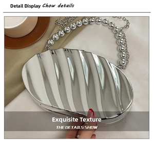 Detail of silver shell-shaped acrylic clutch bag with bead chain and textured mirror finish