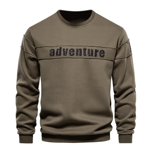 Detail of army green crewneck sweatshirt featuring chest拼接 stitching and adventure print