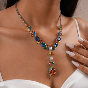 Close-up of a pear-cut multi-colored gemstone necklace with tassel drop on a model