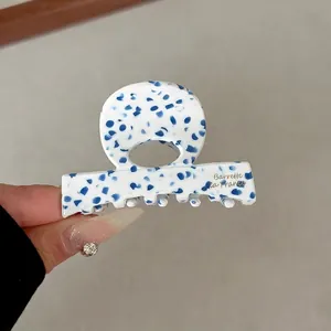 Close-up of a 6cm acetate hair clip with blue terrazzo spots and ring-top design