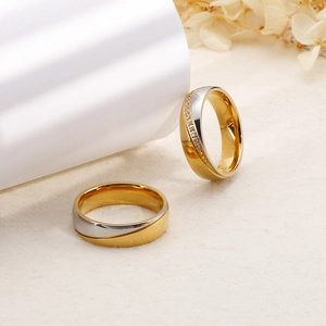 Detail of 6mm two-tone stainless steel couple rings with gold accents and zircon stones