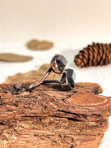 Macro detail of raw black tourmaline stones set on a vintage copper adjustable ring band