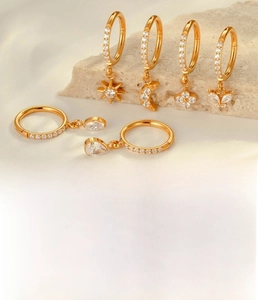 Detailed view of titanium hoop earrings set with moon and star zircon pendants