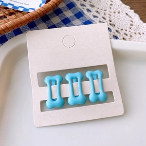 Three-piece sky blue bone-shaped hair clips set on a display card with aesthetic background