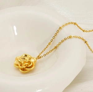 Vue macro d'un collier pendentif rose en plaqué or 18 carats sur porcelaine blanche