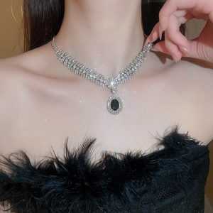 Macro shot of silver-tone collar necklace with multi-row rhinestones and black oval pendant