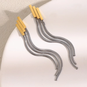 Golden geometric stud earrings with silver snake chain tassels on a white ceramic plate