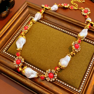 Macro shot of vintage necklace with baroque pearls, red gems and floral crystal charms