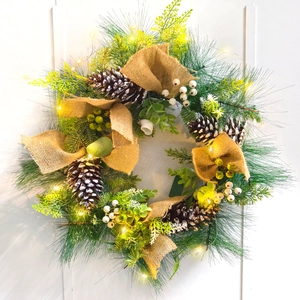 Luminous Christmas wreath with pine cones, needles and warm LED lights on white background