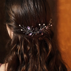 Dettaglio pettine sposa con foglie di gemme viola e strass scintillanti su metallo