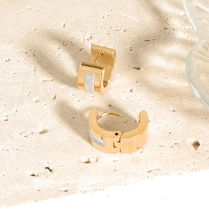 Close-up of gold stainless steel H-shape earrings with white shell inlay details