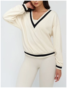 Detail of V-neck collar with black and white striped trim on off-white sweatshirt
