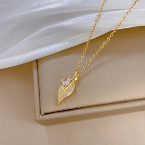 Detailed view of gold leaf pendant with shimmering pavé crystal zircon on a soft silk base