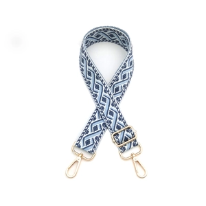 Détail de la bandoulière tissée bohème avec motifs bleus et boucles en métal doré