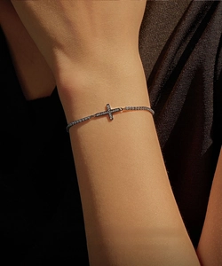 Macro shot of dark gunmetal cross bracelet with shimmering pavé set cubic zirconia