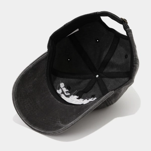 Close-up of the washed cotton baseball cap interior with adjustable metal buckle and strap
