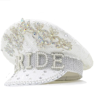 Close-up of white sequin captain hat with BRIDE pearl lettering and rhinestone details