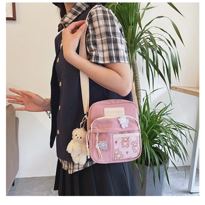 Vue détaillée du sac rose en toile avec pendentif ours en peluche et poches pratiques