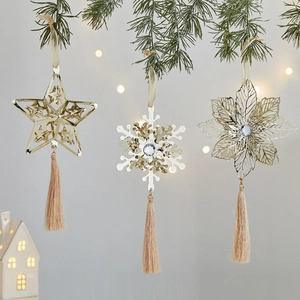 Champagne gold Christmas ornaments with tassels hanging on green pine branches