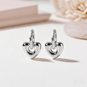 Detailed view of silver heart-shaped stud earrings in a minimalist and elegant setting