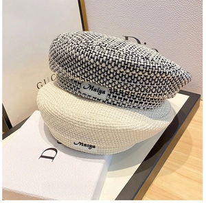 Detail of tweed checkered and beige berets featuring Mniya fabric labels on top