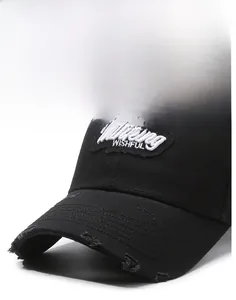 Close-up of distressed brim details and Thinking WISHFUL embroidery on black cotton baseball cap