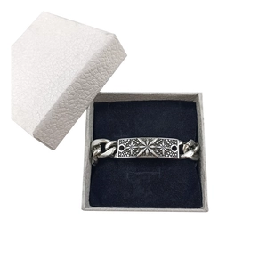 Silver Cuban chain bracelet with star engraved square plate in a gray jewelry box
