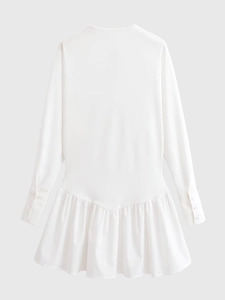 Detail of white long sleeve dress showing buttoned cuffs and pleated ruffle hemline