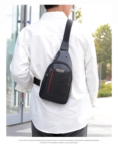 Men's black PU leather sling bag with red stripe detail worn by a model outdoors