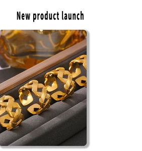 Detail showing twisted texture of 18k gold plated stainless steel open rings in a gray box